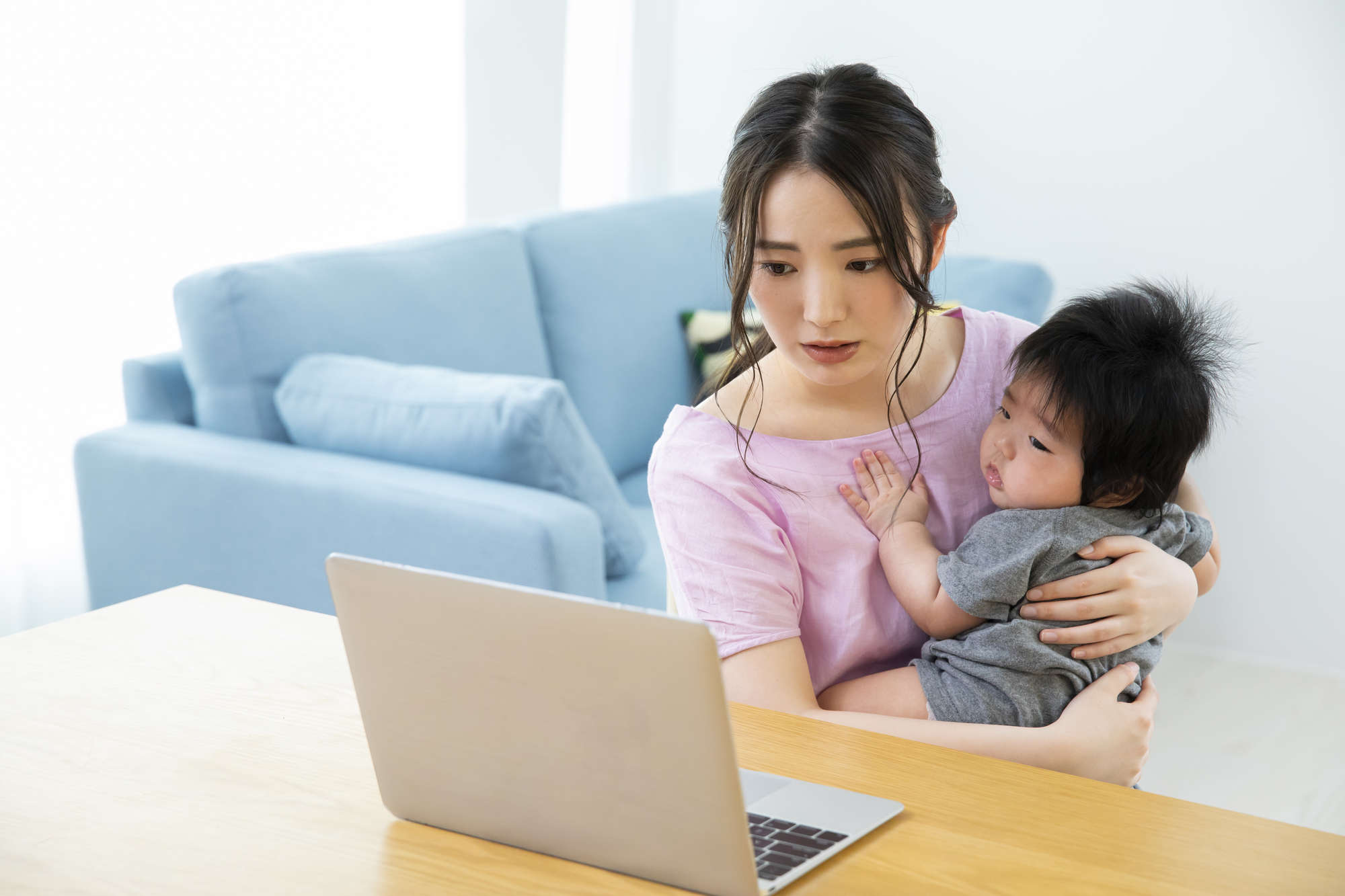 Zoomでやり取りする女性　赤ちゃんを抱っこ