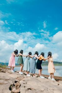 A group of young women in vibrant dresses enjoying a day at the beach.