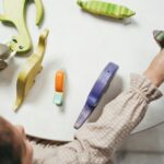 Child playing with colorful wooden toys in a playful indoor setting.