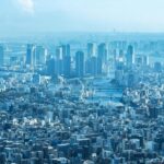 A breathtaking aerial view of Tokyo's urban landscape with prominent skyscrapers under clear skies.