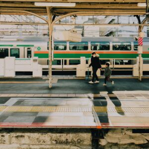 A father and son walk along the platform at a Tokyo train station during the early evening.
