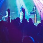 A lively concert scene with musicians performing on stage and an enthusiastic audience.