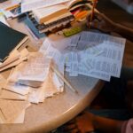 A student organizes notes and books in preparation for an exam, focusing on study materials.