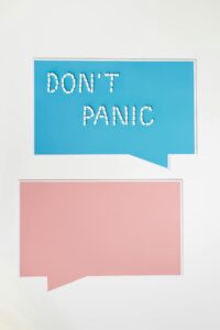 Minimalist design with 'Don't Panic' message in white pills on colorful speech bubble backgrounds.