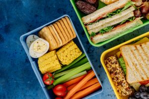 Colorful lunchboxes featuring sandwiches, vegetables, and snacks for healthy eating.