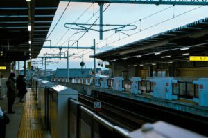 A modern train station platform with commuters waiting during the day.