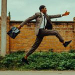 Dynamic image of a businessman leaping energetically outdoors, symbolizing success.