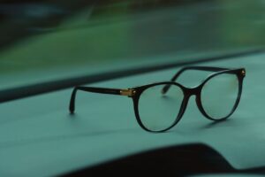 Close-up of stylish black eyeglasses resting on a car dashboard. Perfect for eyewear and fashion themes.