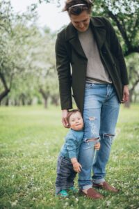 Father and child spending quality time in a lush green park during spring.