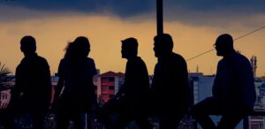Silhouette of diverse group chatting against Bengaluru skyline at twilight.